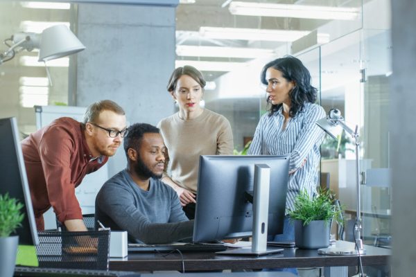 In Busy Corporate Office Team of Diverse Young Creative People Work on a Problem Solution. Collectively They Try to Help Coworker to Solve Problem.